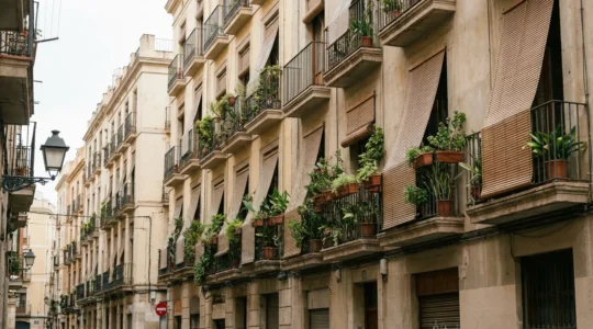 Fachada típica de edificio residencial español con balcones y persianas, precio vivienda España